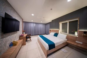 A modern hotel room with a bed, a desk, a chair, a TV, and a window. - Test Harvey's Hotel (Hyderabad)