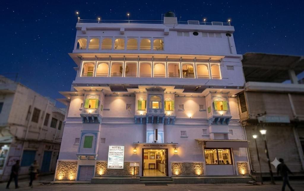 A multi-story hotel with a traditional architectural style, featuring balconies and illuminated windows.