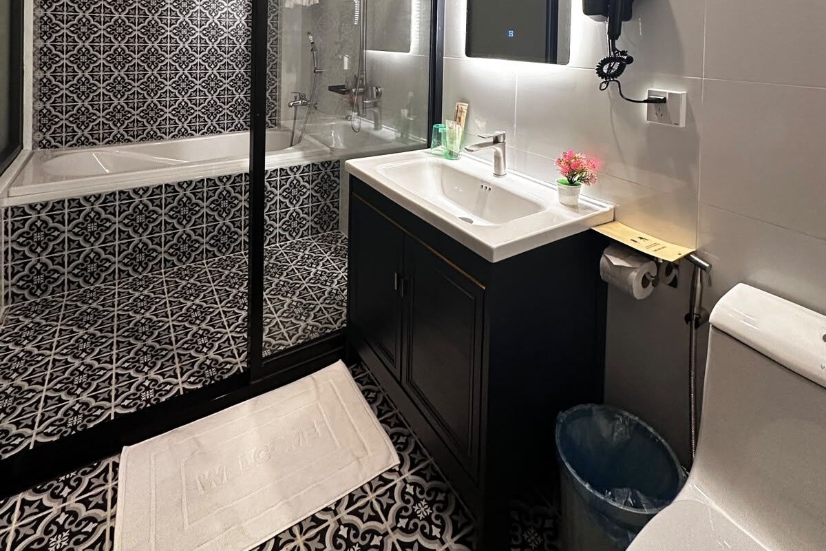 Un baño moderno con ducha de vidrio, tocador con espejo e inodoro.