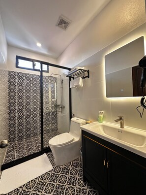 Un baño moderno con ducha, inodoro y lavamanos.