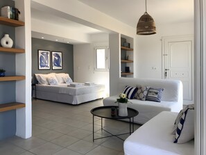 Una sala moderna con un sofá, una mesita de centro y una cama con vistas.