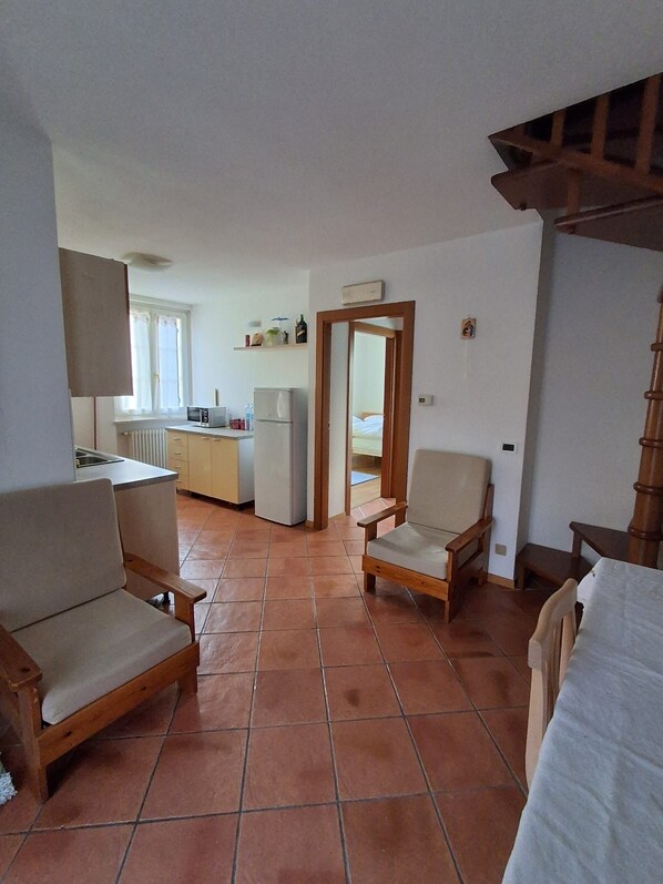 A compact living space with a kitchenette, a dining area, and a bedroom. - Apartment '6 Posti' with Mountain View, Shared Garden and Wi-Fi (Borgo Valsugana)