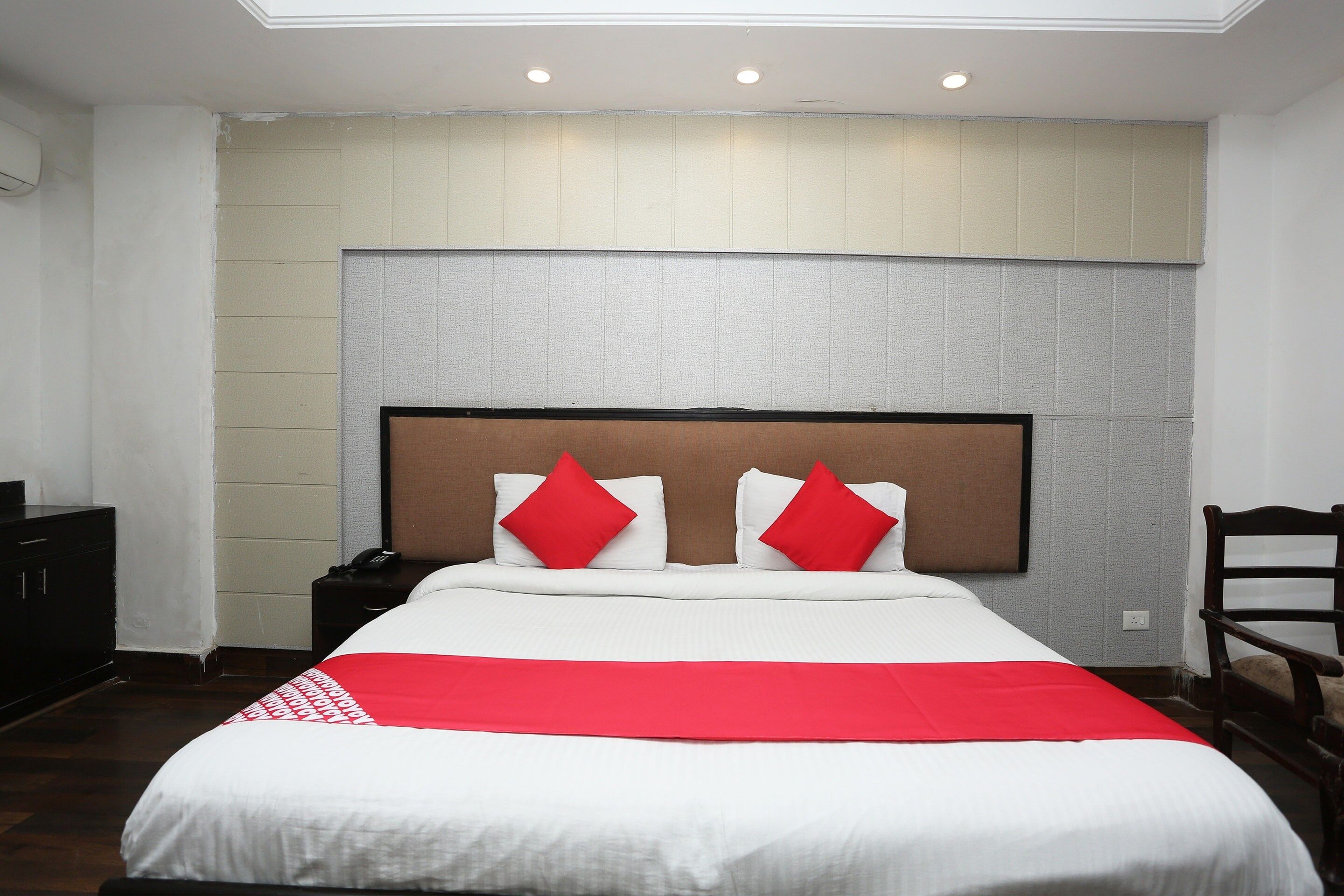 Une chambre d’hôtel avec un lit, une table de chevet, un bureau et une chaise.