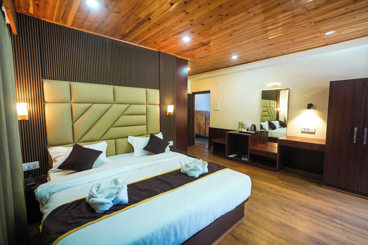 Een hotelkamer met een groot bed, houten plafond en een spiegel.