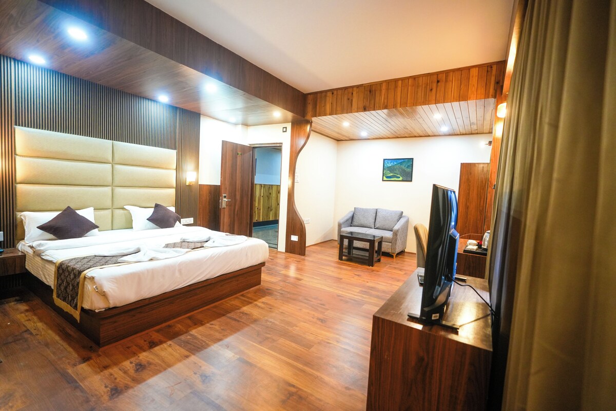 Een moderne hotelkamer met een groot bed, een zithoek en een televisie.