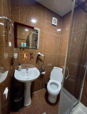 A bathroom with a sink, toilet, and shower. - Hotel Marioni (tbilisi)