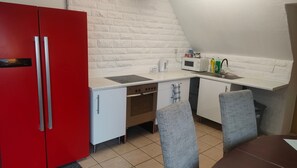A compact kitchenette with a red refrigerator, a microwave, a sink, and a stove. - Apartment 'Marienmünster' with Wi-Fi (Marienmünster)