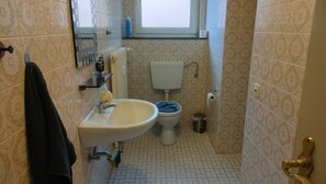 A bathroom with a sink, toilet, and a window. - Apartment 'Marienmünster' with Wi-Fi (Marienmünster)