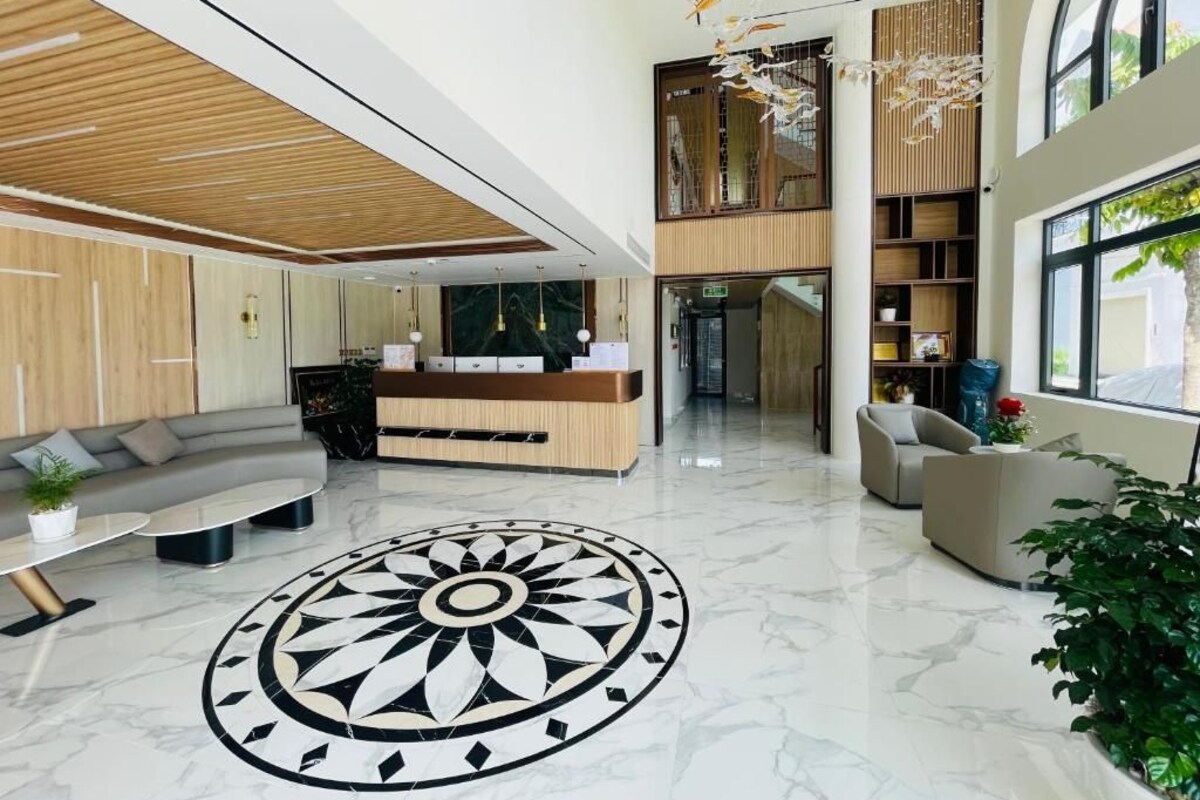 A modern lobby with a reception desk, seating area, and a large decorative floor pattern.