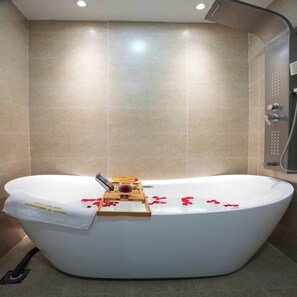 A modern bathroom with a freestanding bathtub, a showerhead, and a towel rack. - HOTEL SALA LAN ANH (Phuoc An)