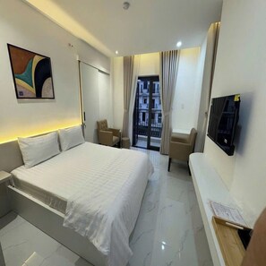 A hotel room with a bed, a seating area, a television, and a view of the outside. - HOTEL SALA LAN ANH (Phuoc An)