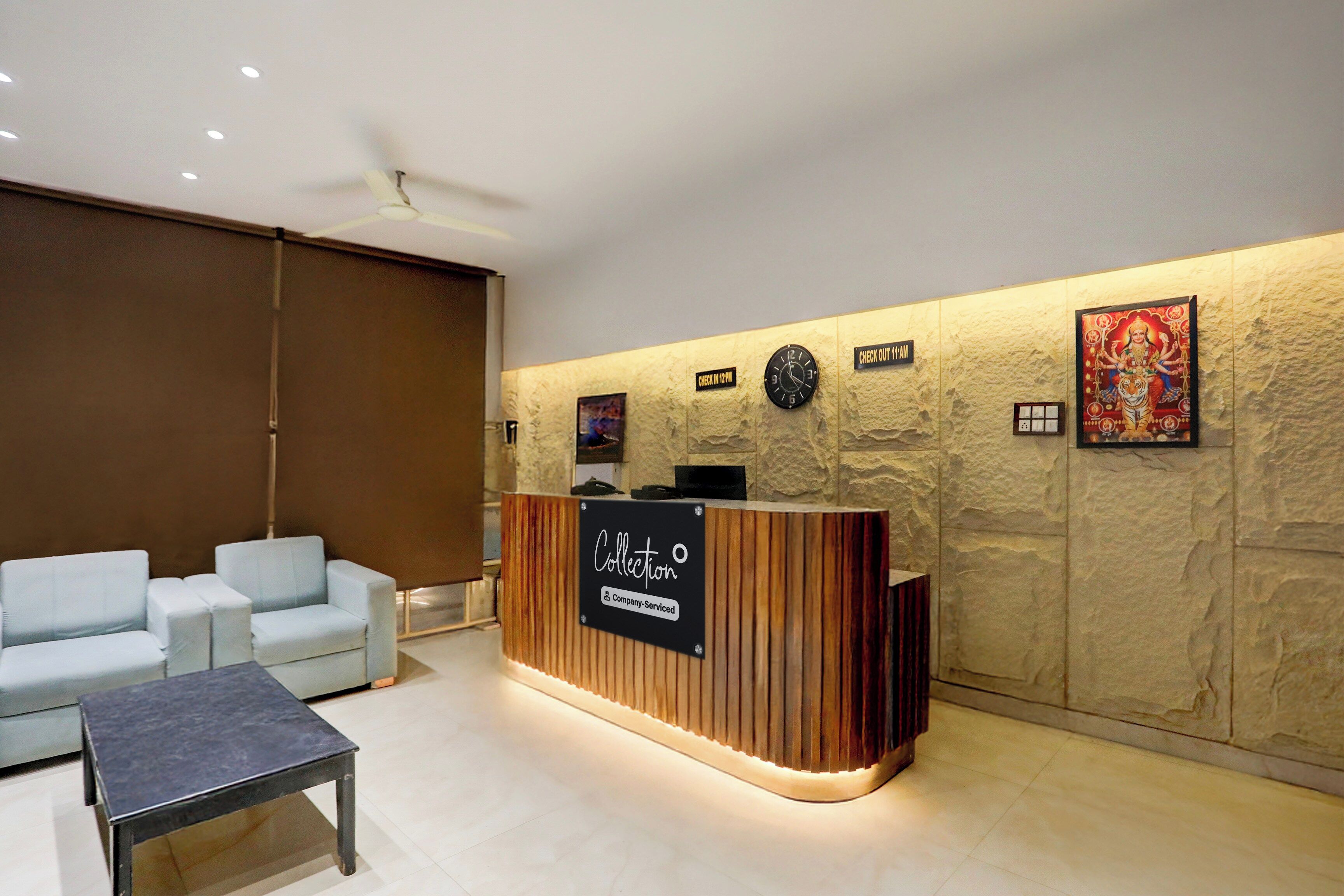 A reception area with a wooden reception desk, a clock, and a wall-mounted sign indicating check-in times.