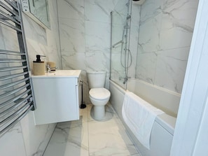 Ein Badezimmer mit Toilette, Waschbecken, Dusche und Badewanne.