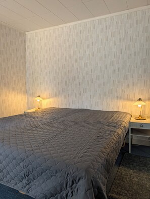 A bedroom with a bed, two bedside lamps, and a nightstand. - Lillhamra Cottage, in the heart of swedish nature (Lillhamra)