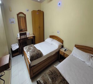 Quarto com uma cama de solteiro, mesa de cabeceira, guarda-roupa de madeira, escrivaninha com cadeira e espelho.