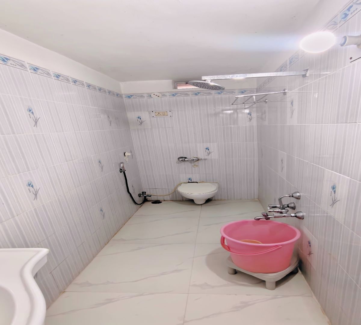 A small bathroom with a toilet, a sink, and a shower area.