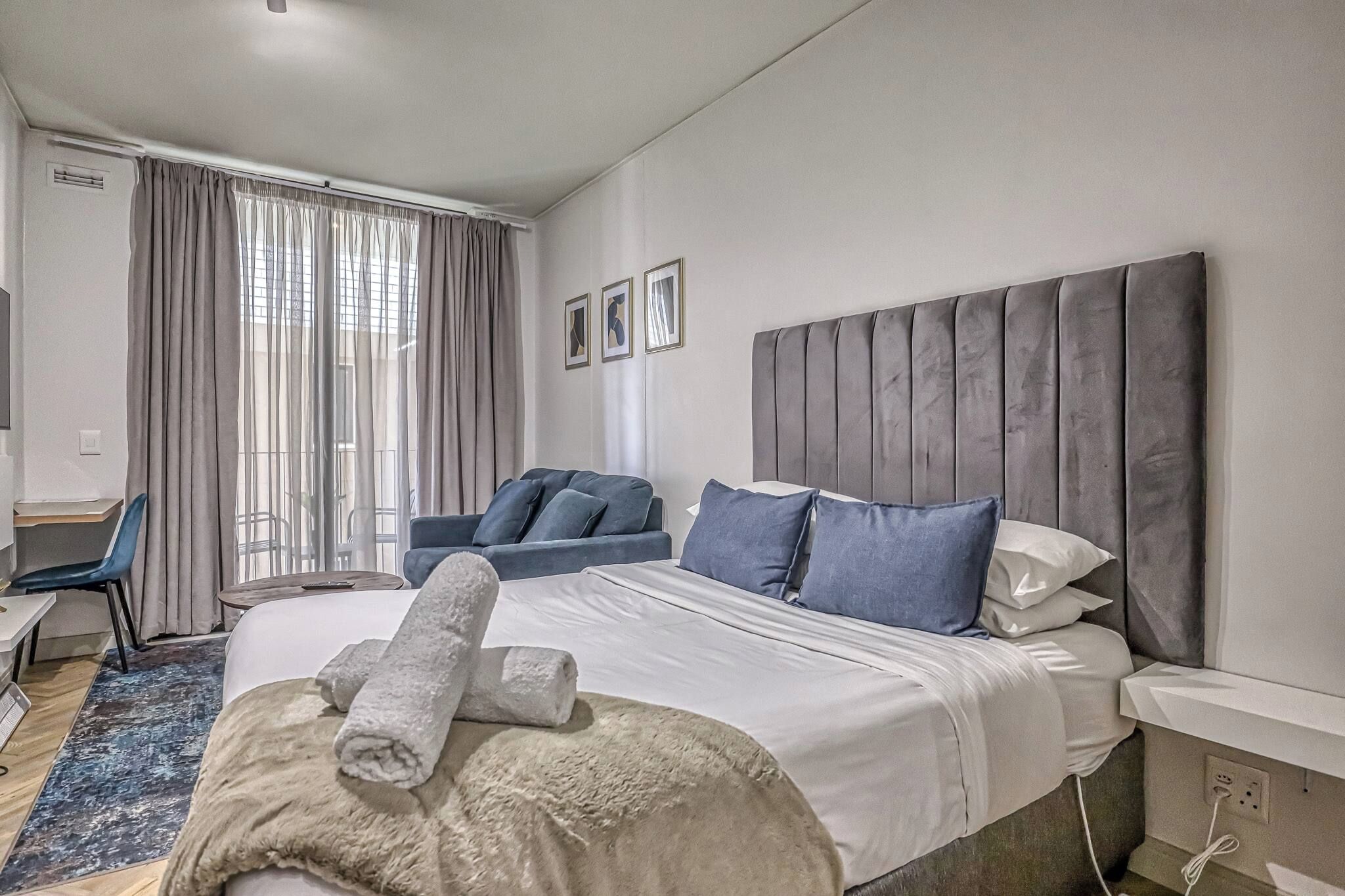Una habitación de hotel con cama, sofá, escritorio y silla.