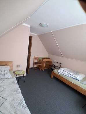 Ein Schlafzimmer mit Bett, Schreibtisch, Stuhl und einem kleinen Tisch.