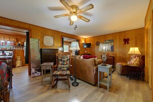 Una sala de estar acogedora con ventilador de techo, chimenea y zona de café.