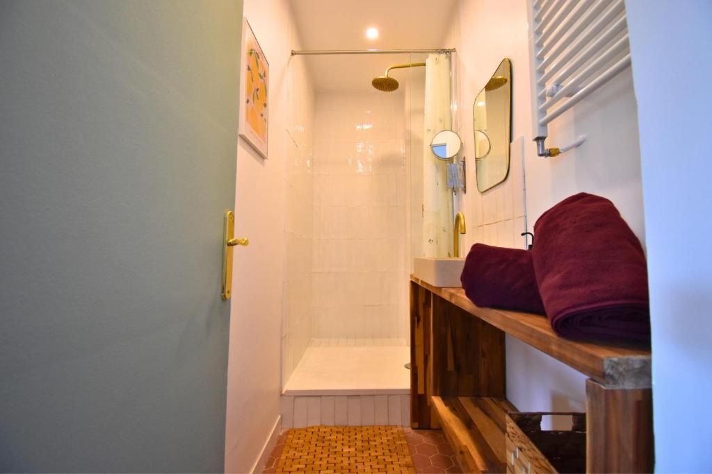 Ein Badezimmer mit Dusche, Waschbecken, Spiegel und Handtuchhalter.
