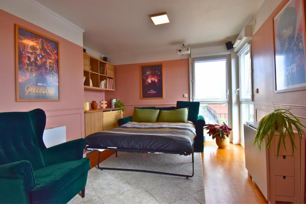 Un dormitorio con una cama, un sillón verde, una estantería y una ventana.