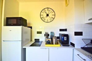 Eine Küche mit Mikrowelle, Toaster und einer Uhr an der Wand.