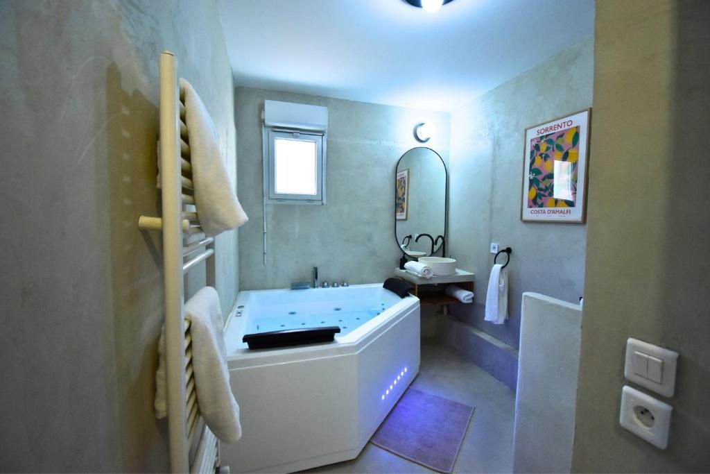 Un baño con bañera, lavamanos, espejo y perchero para toallas.