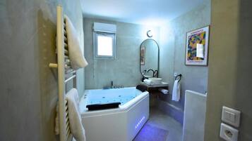 Ein Badezimmer mit Badewanne, Waschbecken, Spiegel und Handtuchhalter.