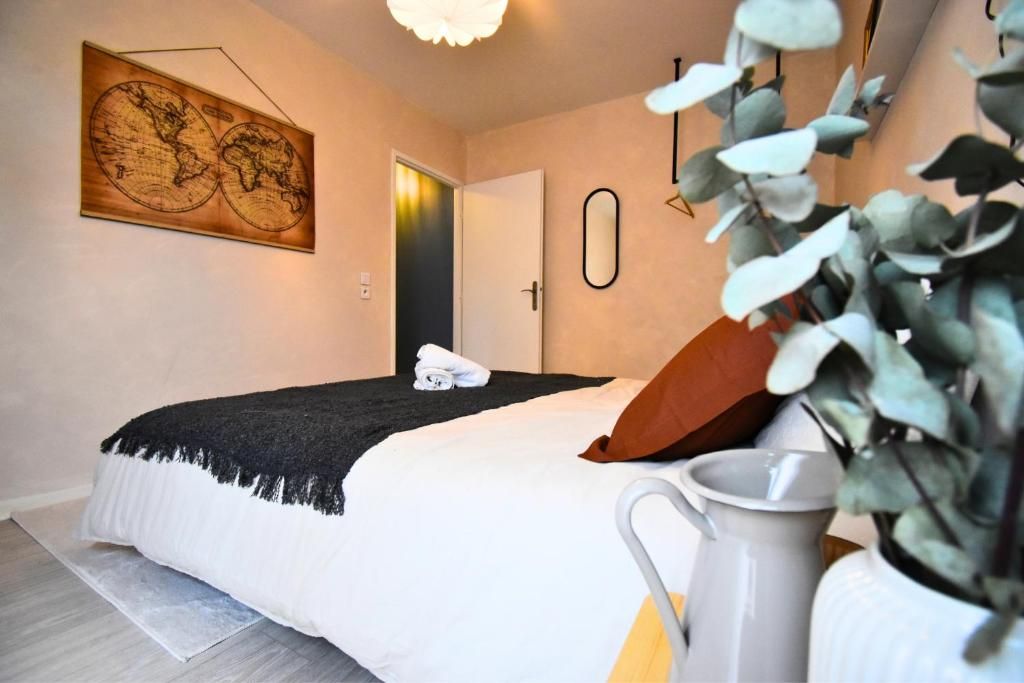Un dormitorio con cama, un mapa en la pared, una puerta y una planta.