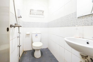 Et lille, rent badeværelse med toilet, håndvask og brusebad.