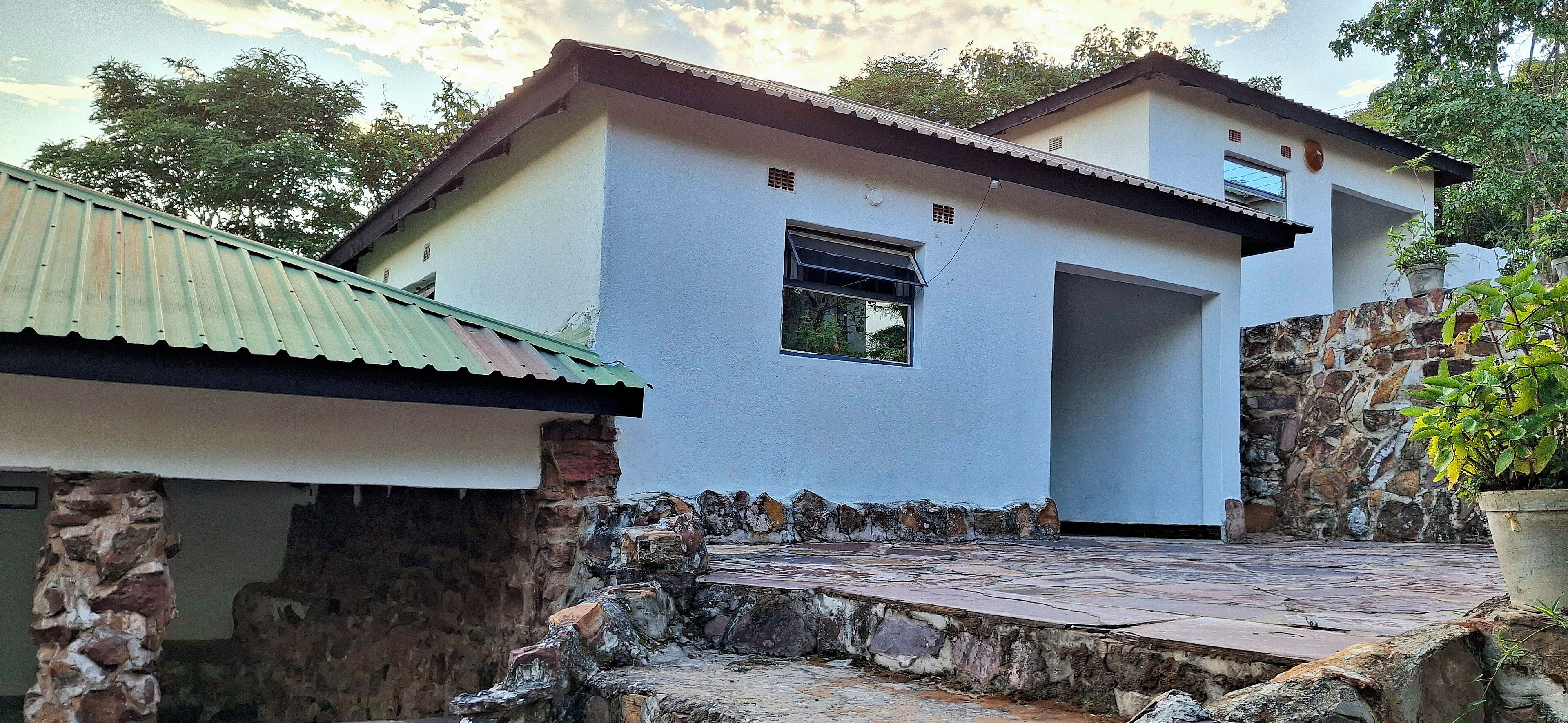 Un bâtiment à deux étages, doté de fondations en pierre et d’une terrasse carrelée.