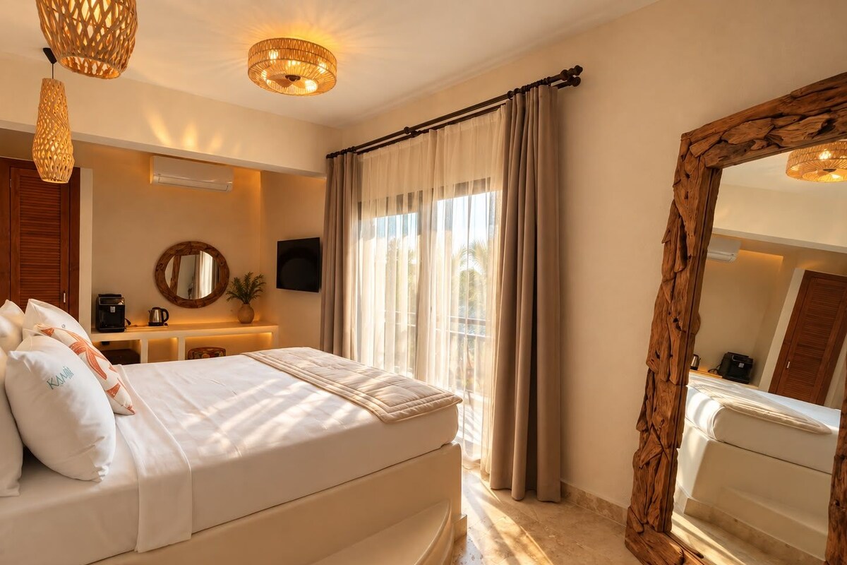 Une chambre d’hôtel avec un lit, un grand miroir, une télévision et une fenêtre avec des rideaux.
