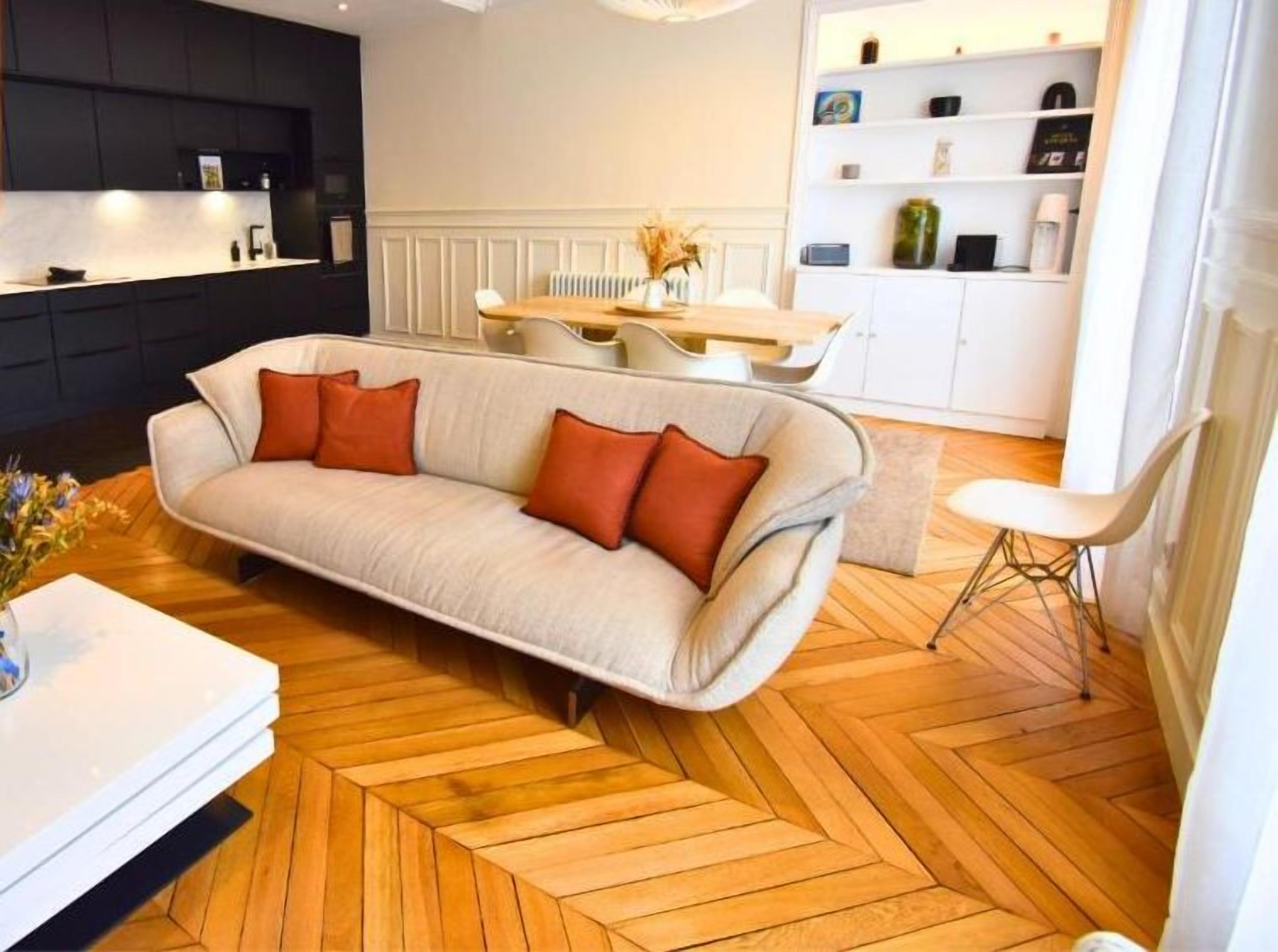 Un salon moderne comprenant un canapé, une table à manger et un coin cuisine.