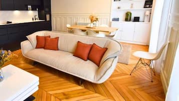Un salon moderne comprenant un canapé, une table à manger et un coin cuisine.