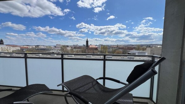 Un balcone con vista su un paesaggio urbano, che include edifici e un fiume.