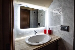 A modern bathroom with a marble sink, a mirror, and a hand dryer. - Holiday Apartment 'La Casa Dei Bersaglieri' (Perugia)