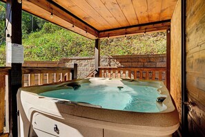 Slip into the warm, bubbling waters and let your worries melt away in this private covered hot tub. Surrounded by nature and tucked away for your relaxation, it's your perfect retreat after a day of adventure. - Spacious Retreat with Hot Tub, Firepit & Easy Access (Sevierville)