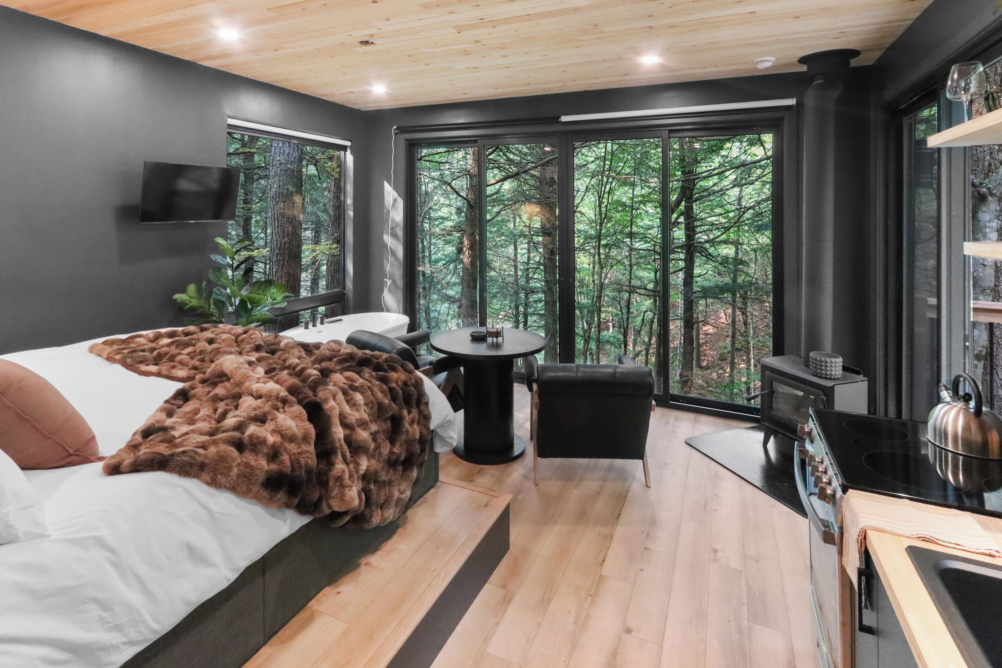 Une chambre moderne avec un grand lit, une petite table et une cheminée.