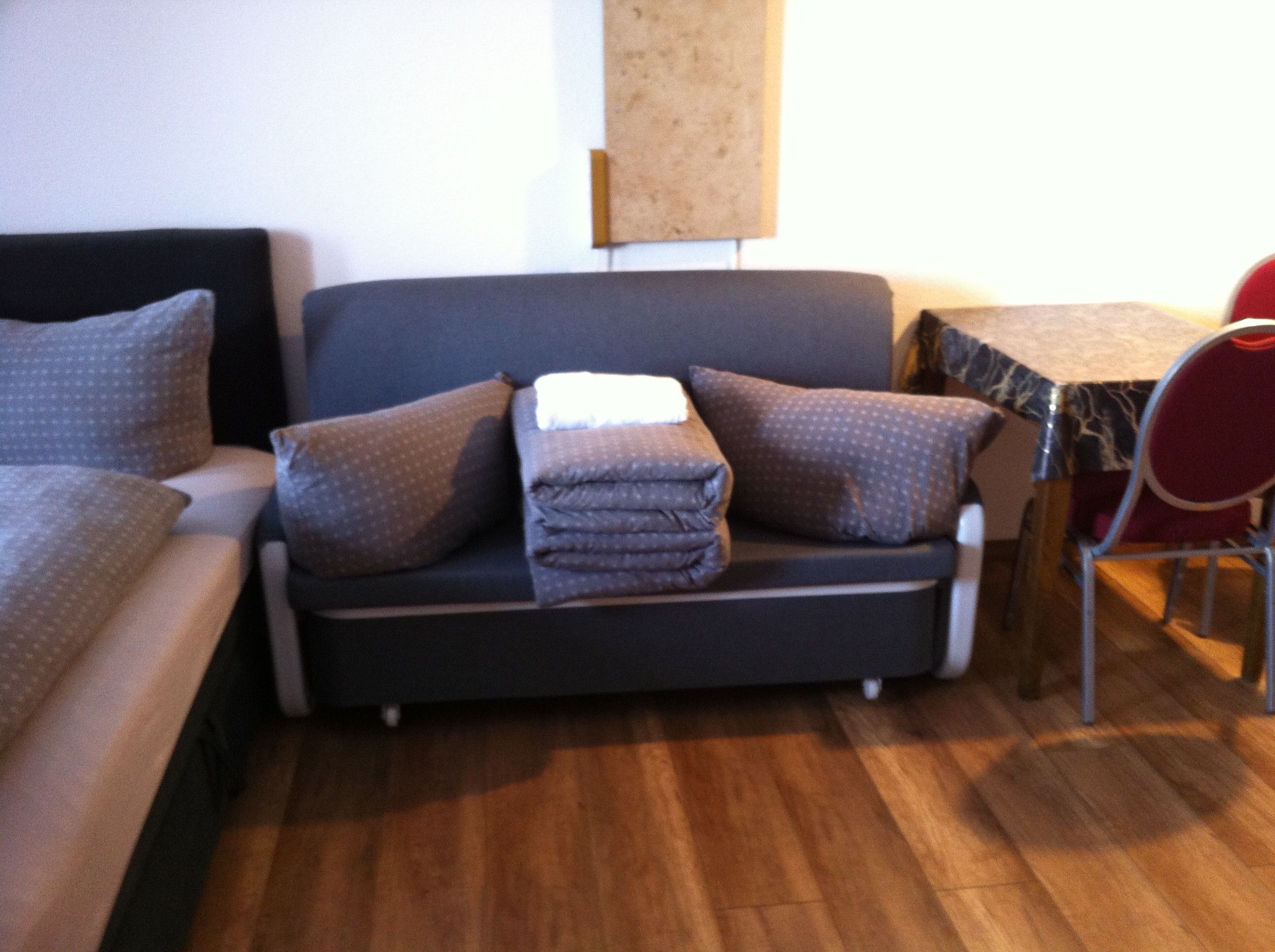 Ein Zimmer mit einer Couch, einem Sessel und einem kleinen Tisch.