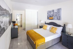A modern bedroom with a large bed, bedside tables, a wardrobe, and a cityscape painting. - Quinta Aida Farmhouse Rooms (Lagoa)