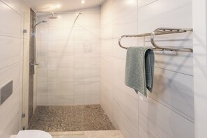 A modern bathroom with a shower, tiled walls, and a towel rack. - Quinta Aida Farmhouse Rooms (Lagoa)