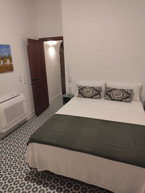 A room with a bed, a heater, a door, and a wall-mounted picture. - New Listing (Campo de Criptana)