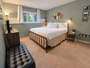 A bedroom with a bed, bedside table, lamp, and a bench. - Heart of Wintergreen 1BR - Fully Stocked, Year-Round, Couples & Families (Wintergreen Resort)