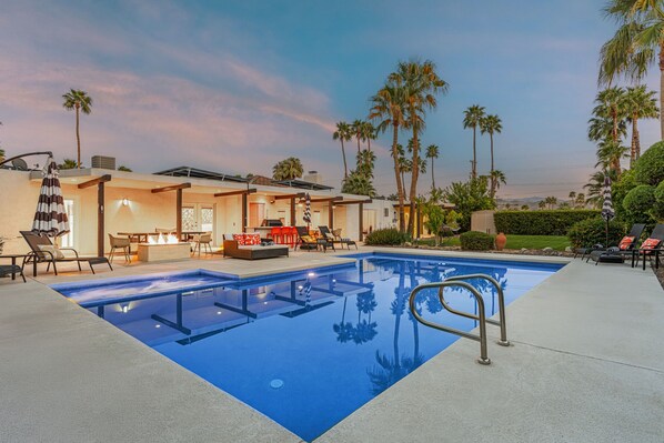 A swimming pool with a sunken deck, lounge chairs, and a barbecue area. - Palm Springs Oasis | Private Pool, Spa & Game Room (Palm Springs)