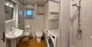 Ein Badezimmer mit Waschbecken, Bidet, Toilette und Waschmaschine.
