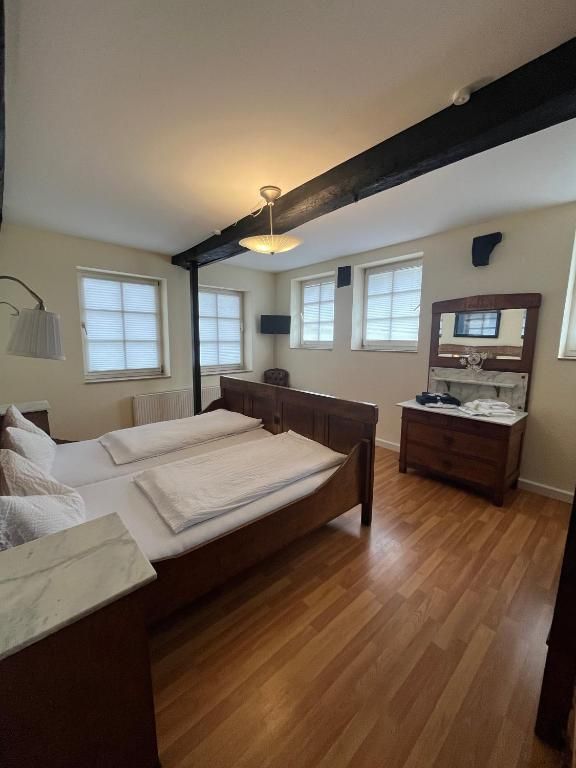 Ein Schlafzimmer mit einem großen Bett, einem Schminktisch, einem Spiegel und einem Deckenventilator.