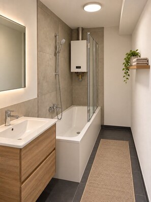 Une salle de bain moderne avec un meuble-lavabo à deux vasques, une baignoire sur pieds et un porte-serviettes avec des serviettes pliées.