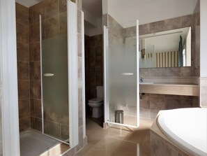 Une salle de bain moderne avec une douche à parois de verre, des toilettes et un lavabo avec un miroir au-dessus.
