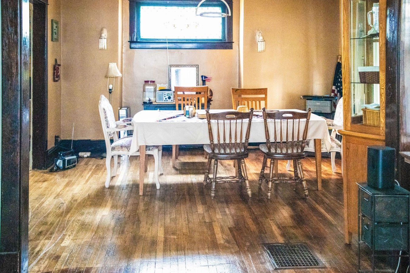 Comedor con una mesa preparada para cuatro personas, rodeado de sillas de madera.