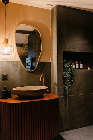 A modern bathroom with a round sink, a mirror, and a pendant light. - Mana Suite & Spa - Luxury & Wellness (Tarare)